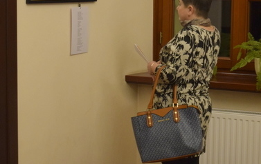 kobieta oglądająca fotografie na ścianie