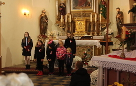 Grupa dzieci stojąca przed ołtarzem 