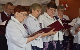 Panie z klubu seniora trzymają śpiewniki i śpiewają piosenki patriotyczne 