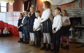 Uczniowie stoją w dw&oacute;ch rzędach i recytują wiersze