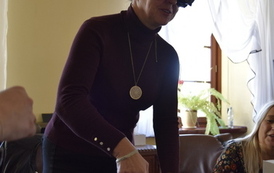 Kobieta w goglach na oczach pr&oacute;buje wlać wodę z dzbanka do szklanki.