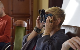 Kobieta przykłada do oczu specjalne gogle zaciemniające.